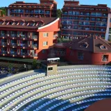 Amfiteatr z białymi siedzeniami i hotelami w tle, idealne miejsce na wieczorne pokazy w club side coast.