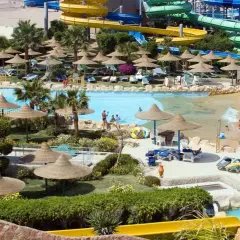 Wodne szaleństwo w Titanic Resort & Aquapark! Kolorowe zjeżdżalnie, baseny i palmy tworzą idealne miejsce na wakacyjny relaks.