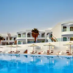 Basen i białe budynki z palmami w Meraki Resort Sharm El Sheikh. Idealne miejsce na relaks.