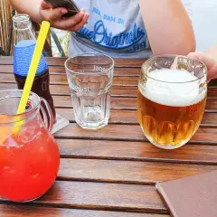Na stole w Pradze dzbanek z napojem, piwo i pusta szklanka. Ceny w Pradze mogą być różne, ale te napoje wyglądają apetycznie.