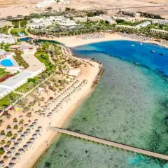 Widok z lotu ptaka na Royal Brayka Beach Resort z basenami, palmami, piaszczystą plażą i turkusowym morzem.