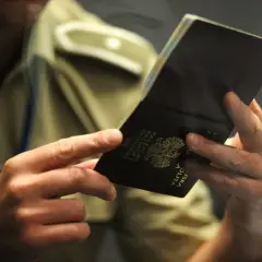 Funkcjonariusz sprawdza paszport, pokazując, ile ważny jest paszport dla podróżujących.