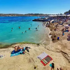 Malta pogoda w maju: słoneczny dzień nad turkusowym morzem, plażowicze kąpią się i opalają.