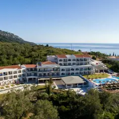 Hotel Saint George Palace z basenem i widokiem na morze, otoczony zielenią.