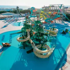 Kolorowy aquapark Fantazia Resort Marsa Alam z licznymi zjeżdżalniami i basenami, w tle morze.