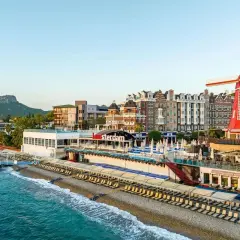 Wyjątkowy Greenwood Kemer Resort z holenderskim wiatrakiem i budynkami w stylu Amsterdamu nad turkusowym morzem.