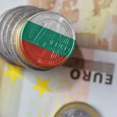 Monety z flagą Bułgarii na tle eurobanknotów. Jaka jest waluta w Bułgarii? To pytanie, na które odpowiedź znajdziemy, analizując te symbole finansowe.