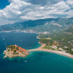 Sveti Stefan, Czarnogóra, idealna pogoda we wrześniu. Wyspa z kamiennymi domkami i plaża z turkusową wodą.