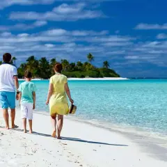 Rodzina spaceruje po rajskiej plaży. Idealne wakacje z dziećmi gdzie? Na pewno tutaj!