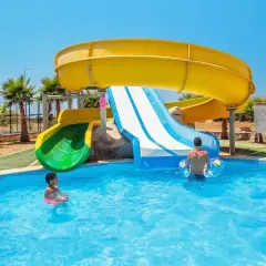 Dzieci bawią się w basenie przy zjeżdżalniach wodnych w **garden of sun spa & wellness**.