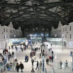 Nowoczesny dworzec Łódź Fabryczna, idealny punkt startowy, by zobaczyć co warto zobaczyć w Łodzi w jeden dzień. Tłumy podróżnych pod imponującym dachem.