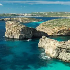 Malta we wrześniu: turkusowa woda, skaliste wybrzeże i łodzie. Idealna pogoda na zwiedzanie.