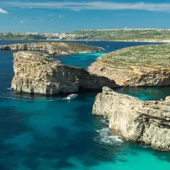 Malta w czerwcu: słoneczna pogoda, turkusowe morze, skaliste wybrzeże i łodzie. Idealne warunki do żeglowania i podziwiania krajobrazów.