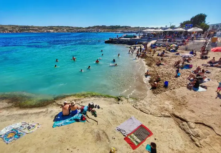 Malta pogoda w maju: słoneczny dzień nad turkusowym morzem, plażowicze kąpią się i opalają.
