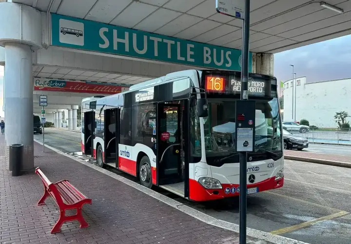 Autobus wahadłowy z lotniska do centrum Bari. Czerwona ławka czeka na pasażerów.