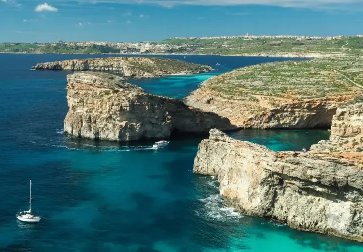Malta w czerwcu: słoneczna pogoda, turkusowe morze, skaliste wybrzeże i łodzie. Idealne warunki do żeglowania i podziwiania krajobrazów.