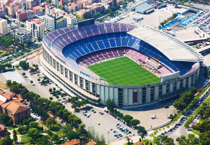 Camp Nou zwiedzanie: imponujący stadion FC Barcelona z lotu ptaka, zielona murawa i niebiesko-bordowe trybuny.