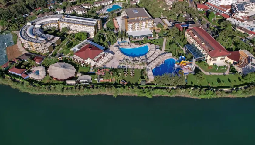 Widok z lotu ptaka na kompleks hotelowy Marvida Family Eco nad jeziorem, z basenami, zjeżdżalniami i terenami zielonymi.