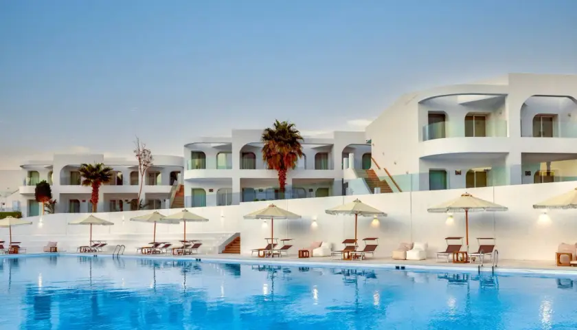Basen i białe budynki z palmami w Meraki Resort Sharm El Sheikh. Idealne miejsce na relaks.