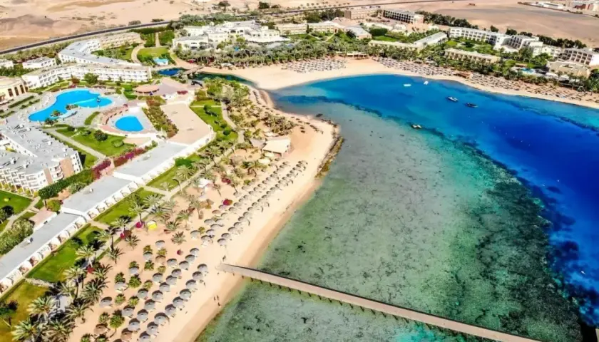 Widok z lotu ptaka na Royal Brayka Beach Resort z basenami, palmami, piaszczystą plażą i turkusowym morzem.