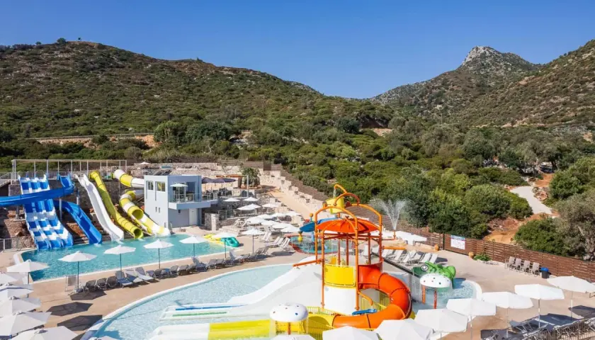 Atali Grand Resort: kolorowy aquapark z licznymi zjeżdżalniami i basenami, otoczony zielonymi wzgórzami.