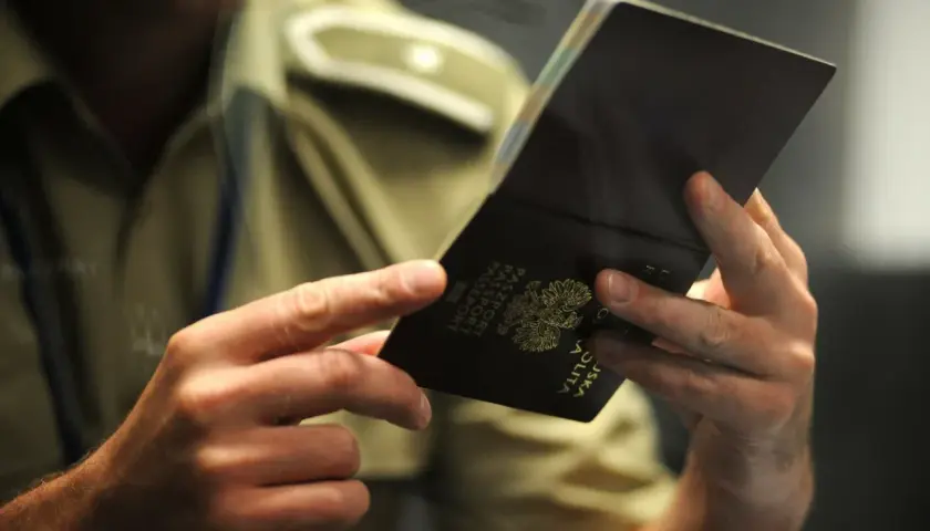 Funkcjonariusz sprawdza paszport, pokazując, ile ważny jest paszport dla podróżujących.