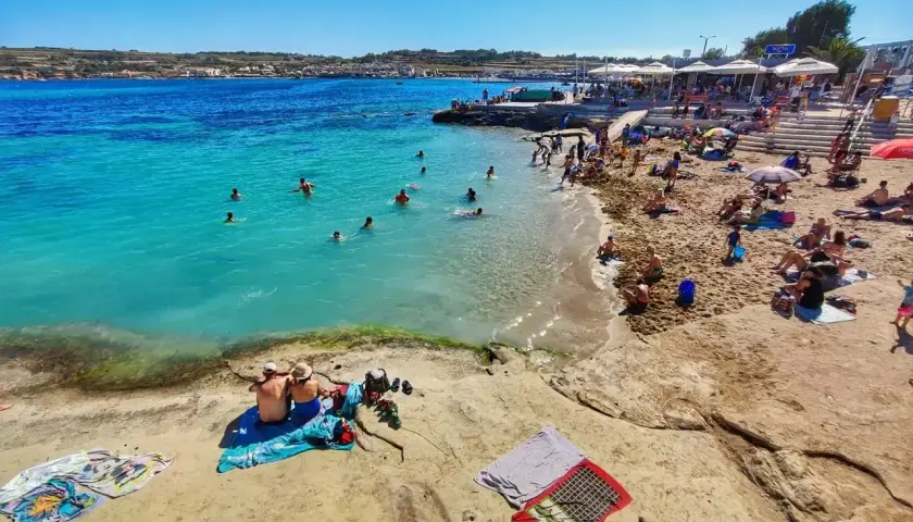 Malta pogoda w maju: słoneczny dzień nad turkusowym morzem, plażowicze kąpią się i opalają.