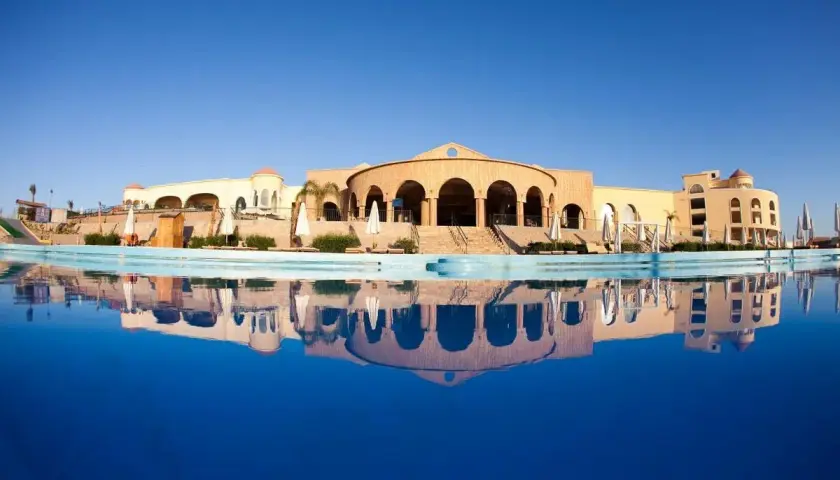 Siva Golden Bay Makadi: hotel z basenem i odbiciem w wodzie, architektura w stylu orientalnym.