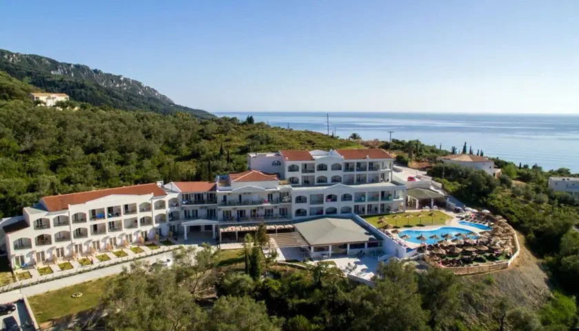 Hotel Saint George Palace z basenem i widokiem na morze, otoczony zielenią.