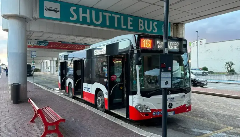 Autobus wahadłowy z lotniska do centrum Bari. Czerwona ławka czeka na pasażerów.