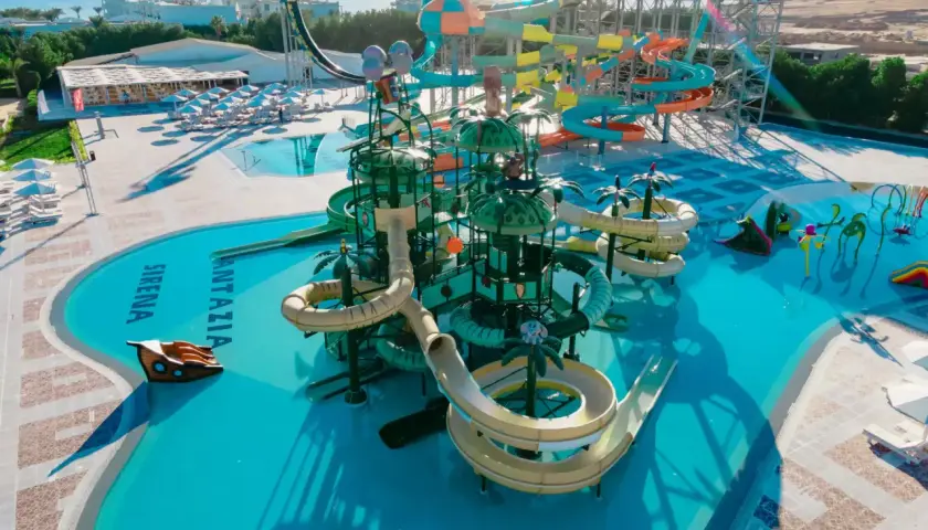 Kolorowy aquapark Fantazia Resort Marsa Alam z licznymi zjeżdżalniami i basenami, w tle morze.