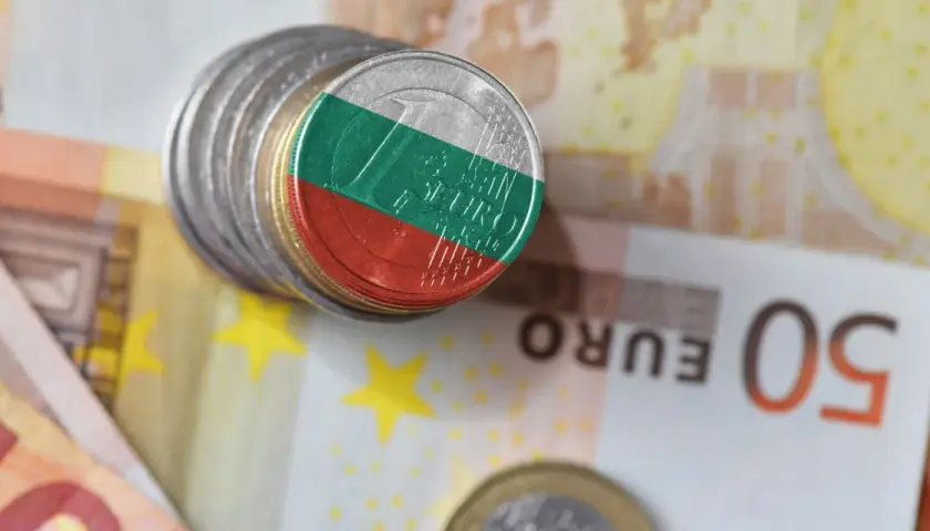 Monety z flagą Bułgarii na tle eurobanknotów. Jaka jest waluta w Bułgarii? To pytanie, na które odpowiedź znajdziemy, analizując te symbole finansowe.