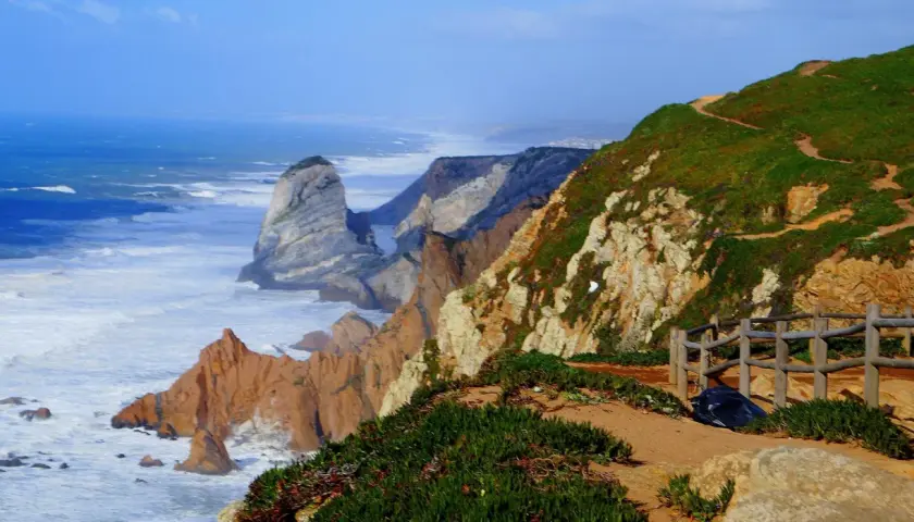 Widok na ocean i klify na Cabo da Roca. Falujące morze uderza o skaliste wybrzeże.