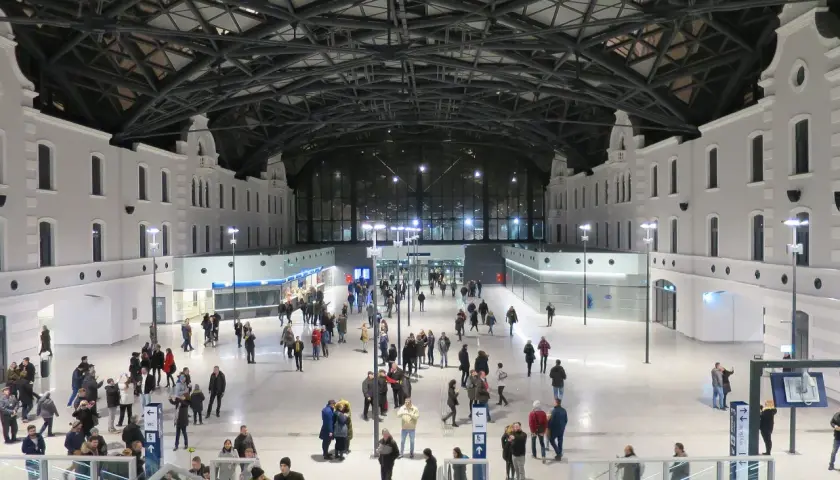 Nowoczesny dworzec Łódź Fabryczna, idealny punkt startowy, by zobaczyć co warto zobaczyć w Łodzi w jeden dzień. Tłumy podróżnych pod imponującym dachem.