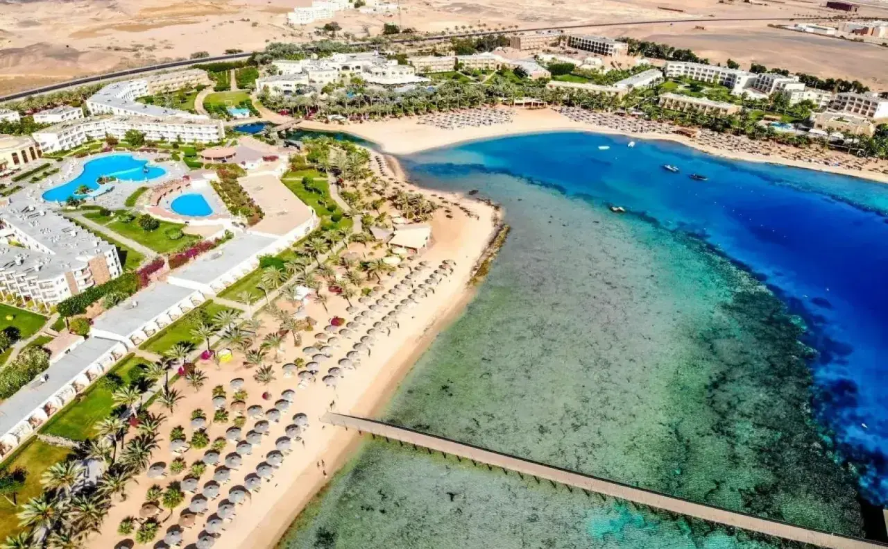 Widok z lotu ptaka na Royal Brayka Beach Resort z basenami, palmami, piaszczystą plażą i turkusowym morzem.