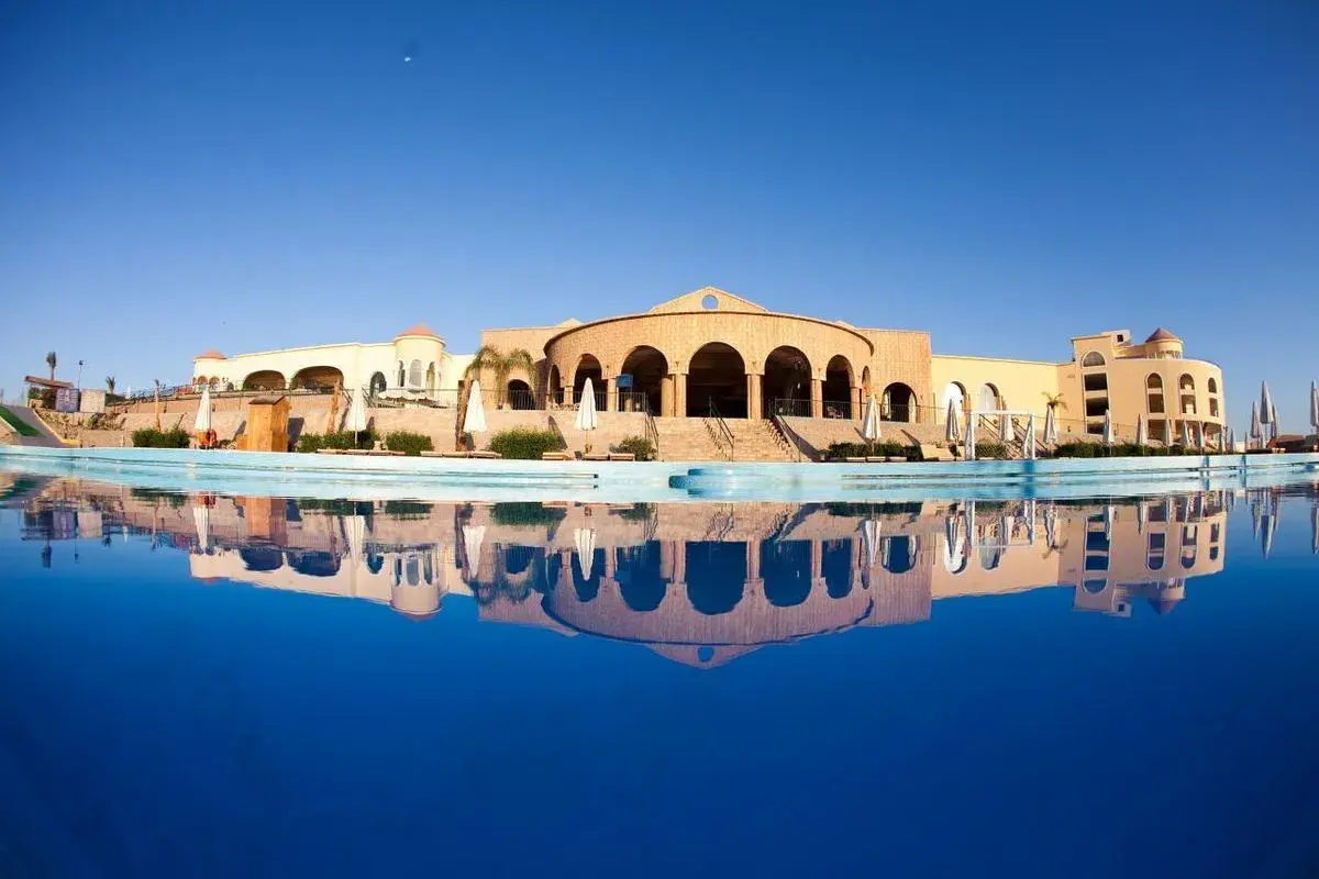 Siva Golden Bay Makadi: hotel z basenem i odbiciem w wodzie, architektura w stylu orientalnym.