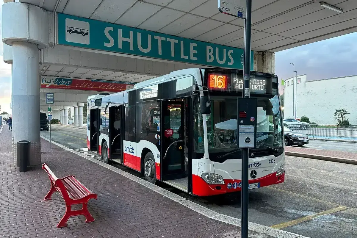 Autobus wahadłowy z lotniska do centrum Bari. Czerwona ławka czeka na pasażerów.