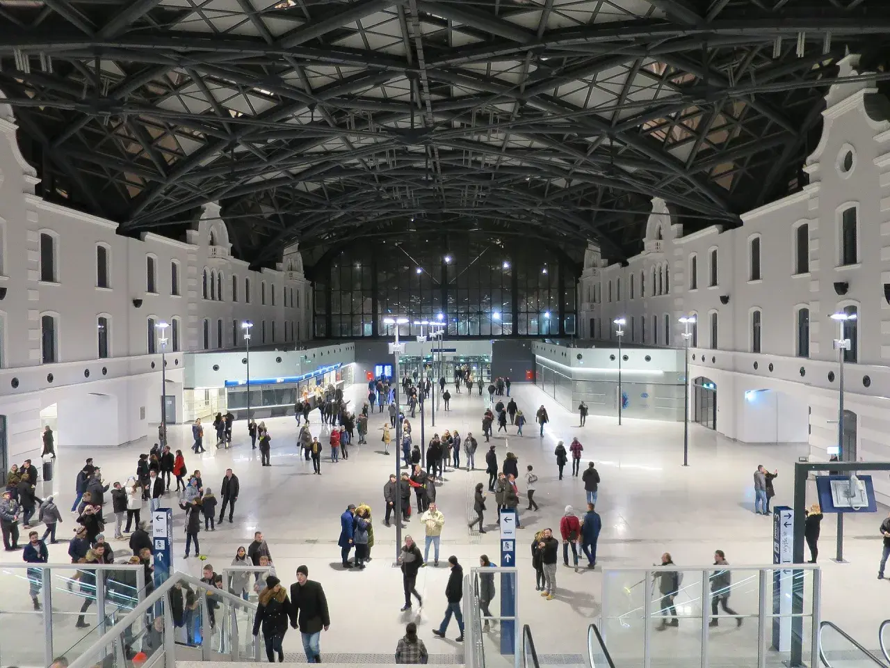 Nowoczesny dworzec Łódź Fabryczna, idealny punkt startowy, by zobaczyć co warto zobaczyć w Łodzi w jeden dzień. Tłumy podróżnych pod imponującym dachem.