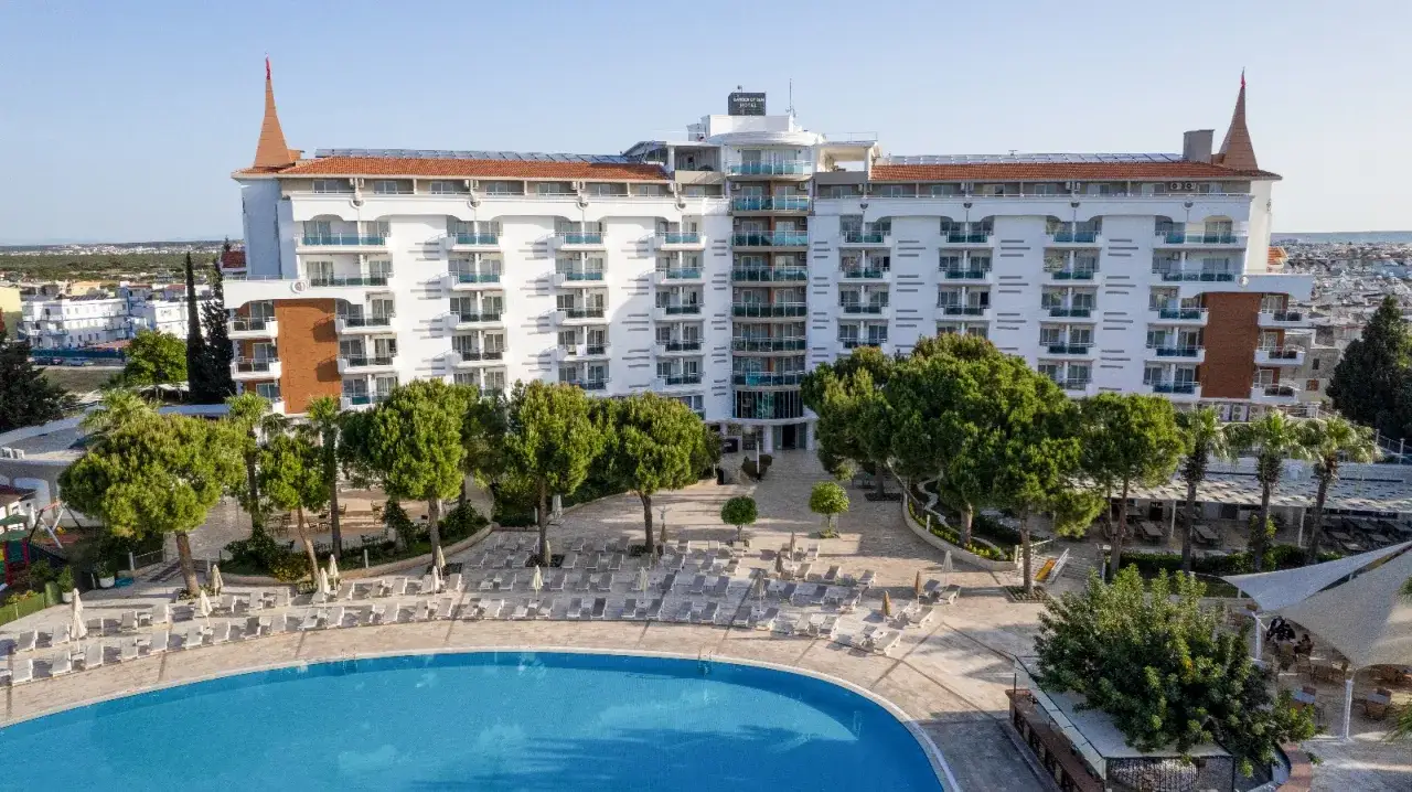 Widok z lotu ptaka na hotel Garden of Sun Spa & Wellness z basenem, leżakami i zielenią.