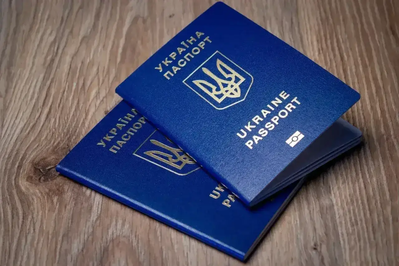 Dwa niebieskie paszporty Ukrainy leżą na drewnianym blacie. Planujesz podróż? Sprawdź, czy do Turcji potrzebny jest paszport.