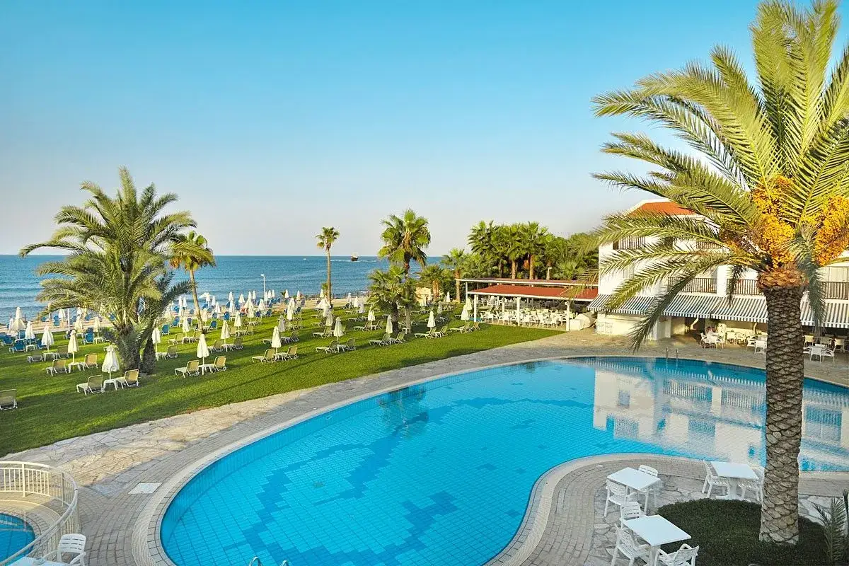 Relaks przy basenie i plaży w Eleni Holiday Village. Palmy, leżaki i błękitne morze tworzą idealne wakacje.
