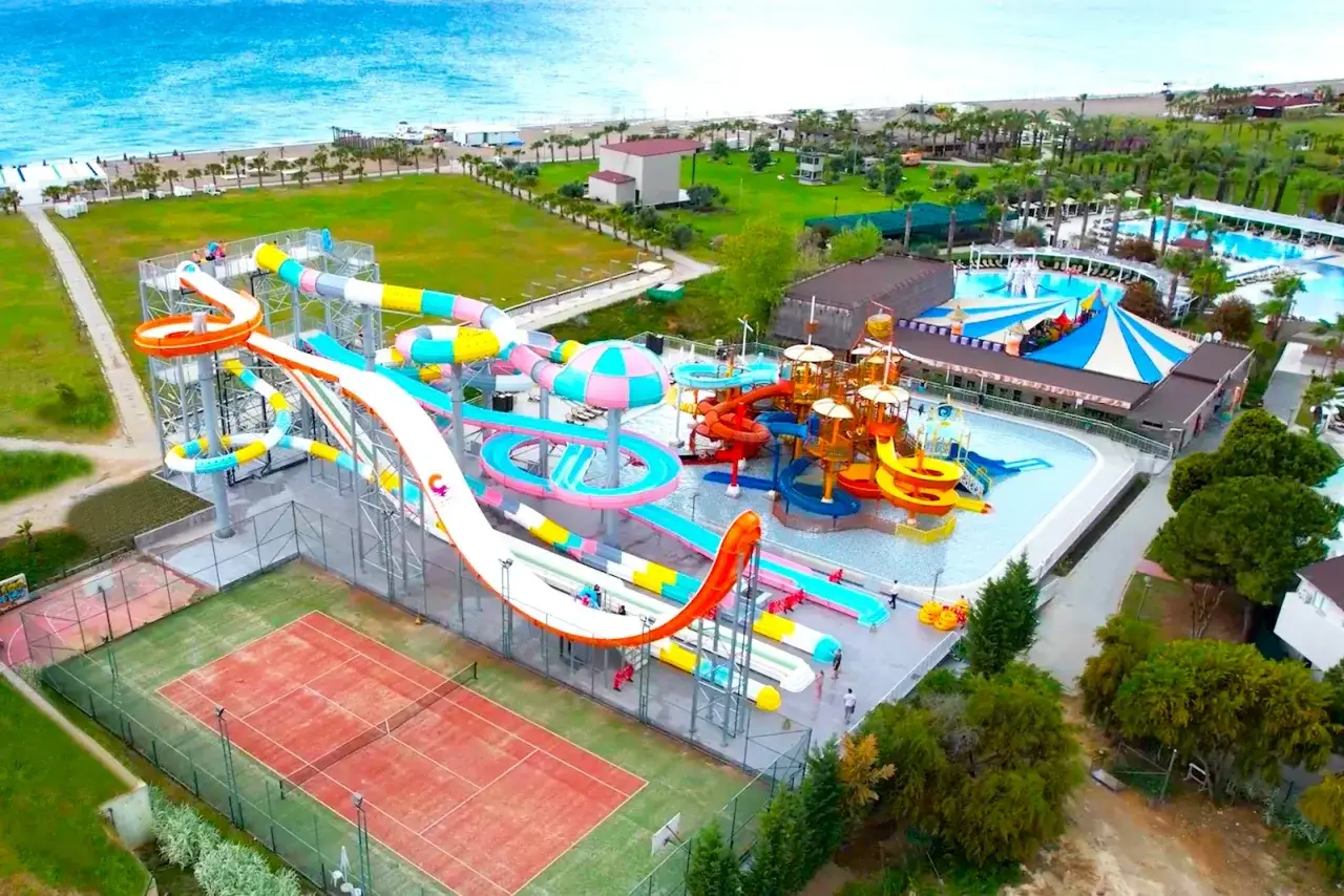 Kolorowy park wodny w Serra Palace w Turcji, z mnóstwem zjeżdżalni i basenów, tuż przy plaży.