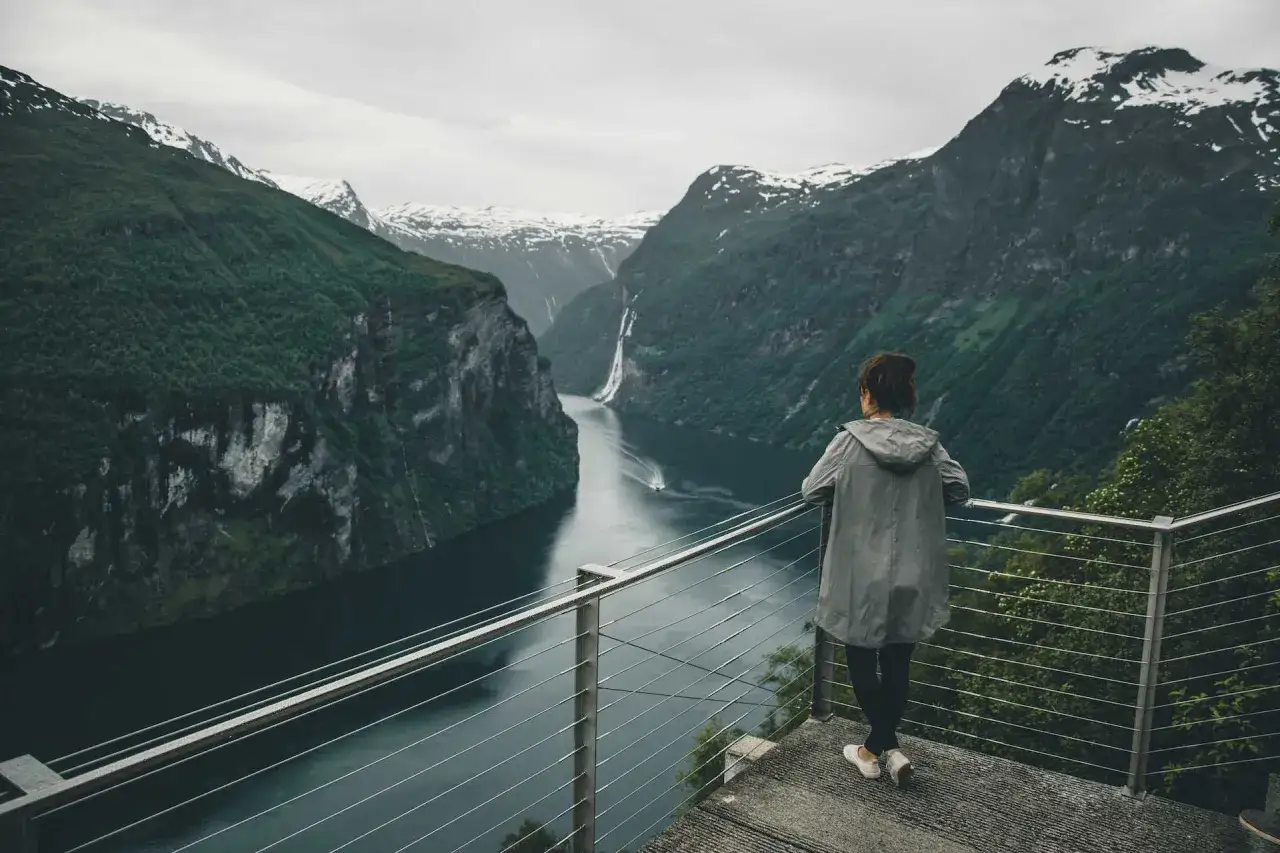 Widok na fiord w Norwegii, z wodospadem i łodzią. Idealne miejsce, by zobaczyć, co Norwegia ma do zaoferowania.