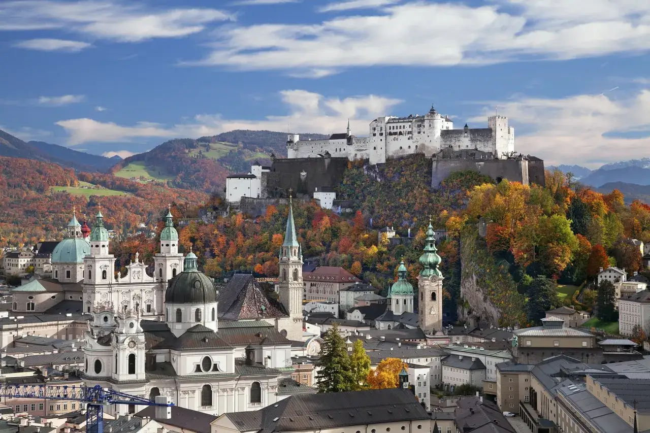 Widok na Salzburg jesienią. Zamek Hohensalzburg góruje nad miastem z kopułami kościołów. Ceny w Austrii mogą być różne, ale widoki są bezcenne.