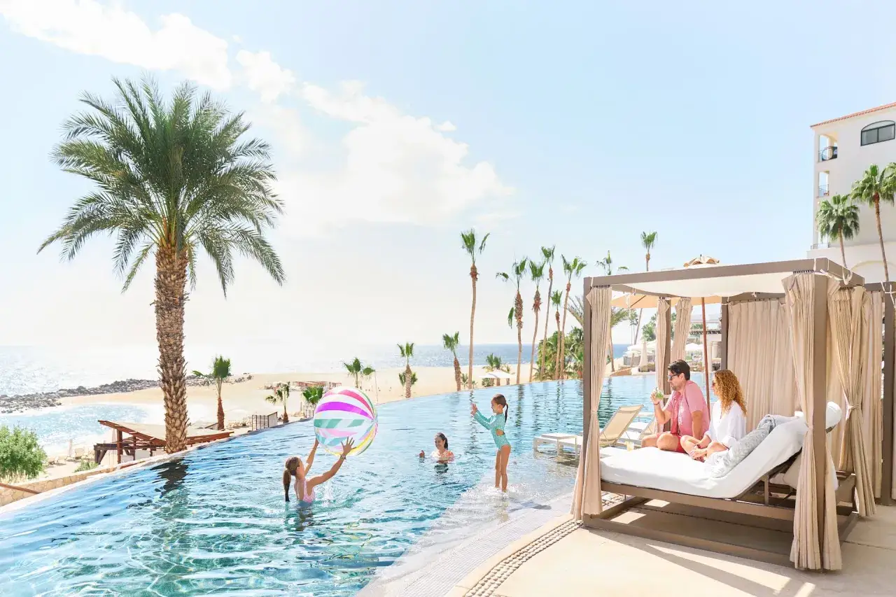 Rodzina bawi się w basenie z widokiem na plażę i morze. Meraki Resort Sharm El Sheikh oferuje idealne wakacje.