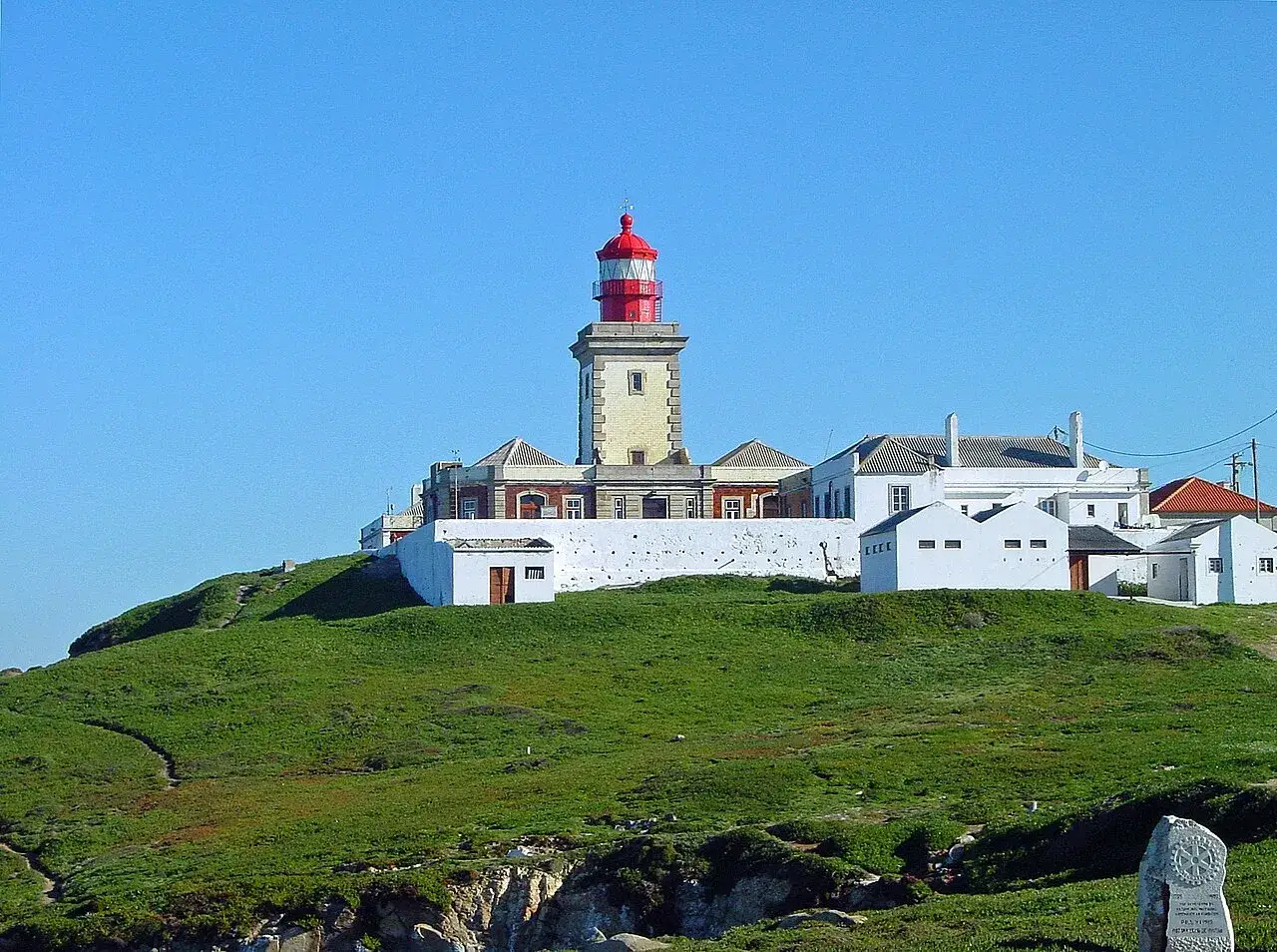 Latarnia morska na Cabo da Roca, najbardziej wysuniętym na zachód punkcie Europy kontynentalnej, góruje nad zielonym wzgórzem.