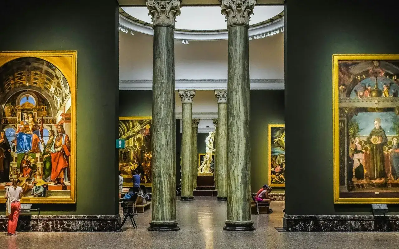 Wnętrze Pinacoteca di Brera z kolumnami i obrazami.