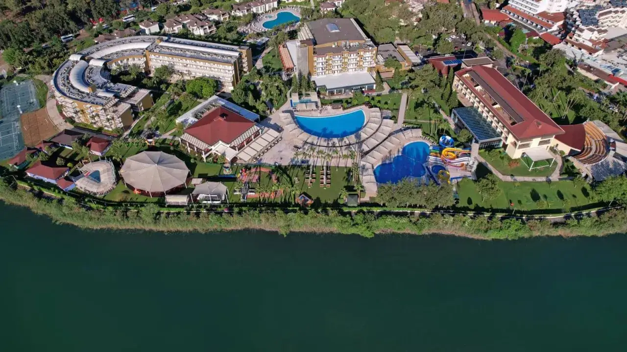 Widok z lotu ptaka na kompleks hotelowy Marvida Family Eco z basenami, zjeżdżalniami i terenami zielonymi nad jeziorem.