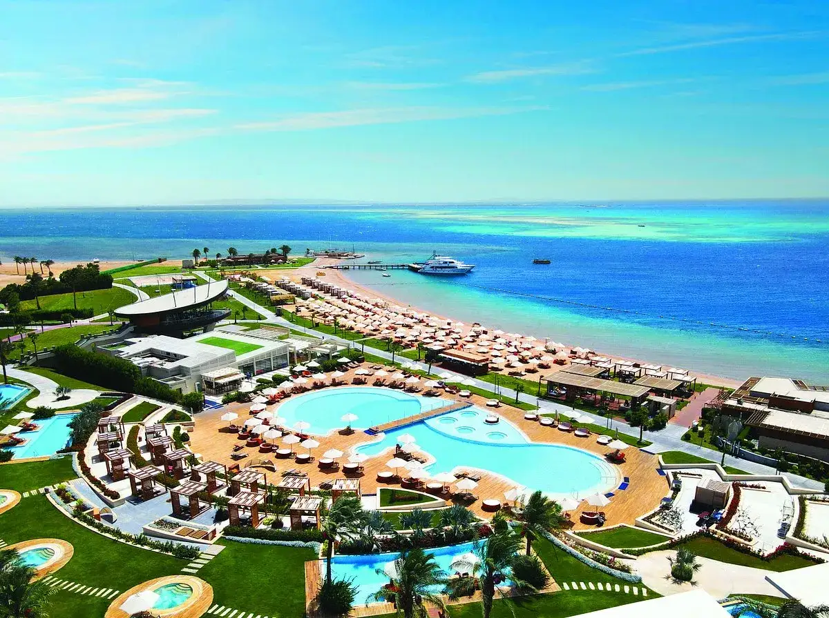 Luksusowy sea gull beach resort z basenami i leżakami nad turkusowym morzem.