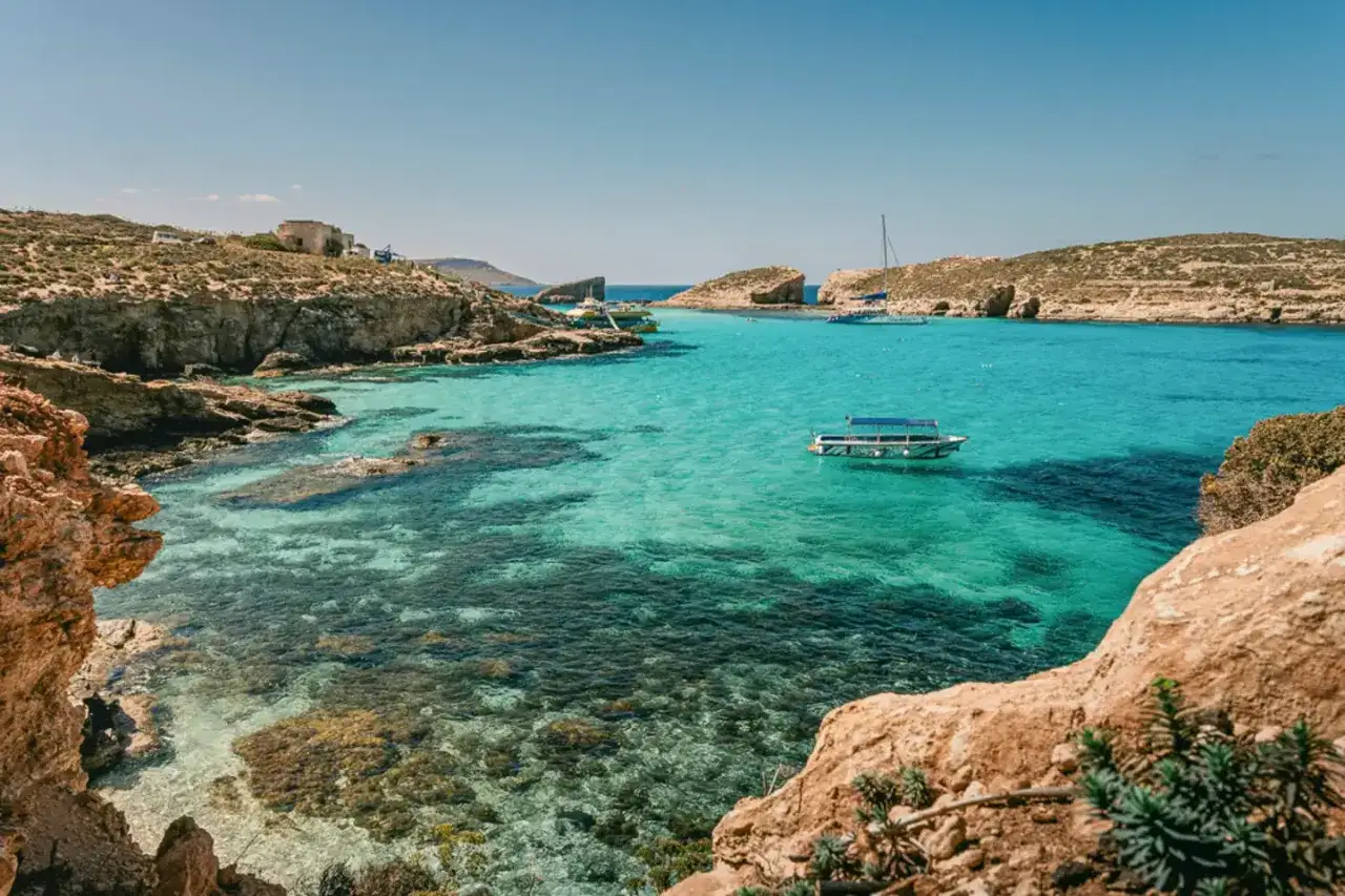 Malta w maju: turkusowa woda, skaliste wybrzeże i łodzie. Idealna pogoda na relaks.